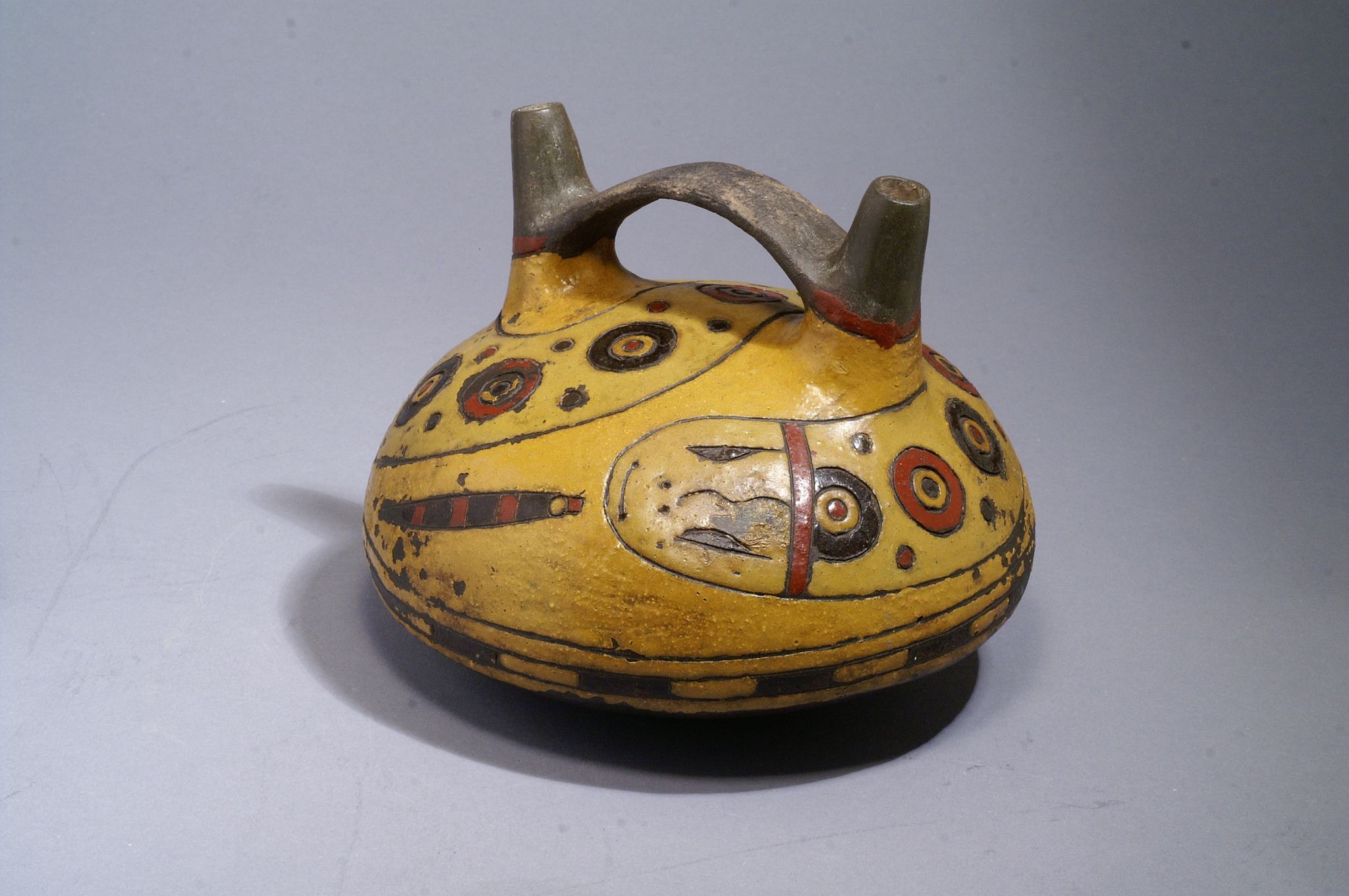 Peru, Paracas Bridge Spout Vessel Painted with Double-headed Undulating Eel
This vessel was painted with two neighboring hues of neutral yellow resinous paint, one for the ground and the other for the double-headed serpent. The rare color palette of this vessel departs from that of most Paracas vessels, which generally employ starkly contrasting colors.  The animal depicted in the painting is probably an Amphisbaena, a species of worm-like snakes whose tails resemble heads as an evolutionary adaptation to fool predators. Acquired from a Miami collector in 2006. Period: Peru, Paracas, Ocucaje Phase 9, Ica valley, South Coast, c. 300 - 200 BC
Media: Ceramic
Dimensions: Diameter: 6 1/4" x Height: 5"
$8,750
M6088