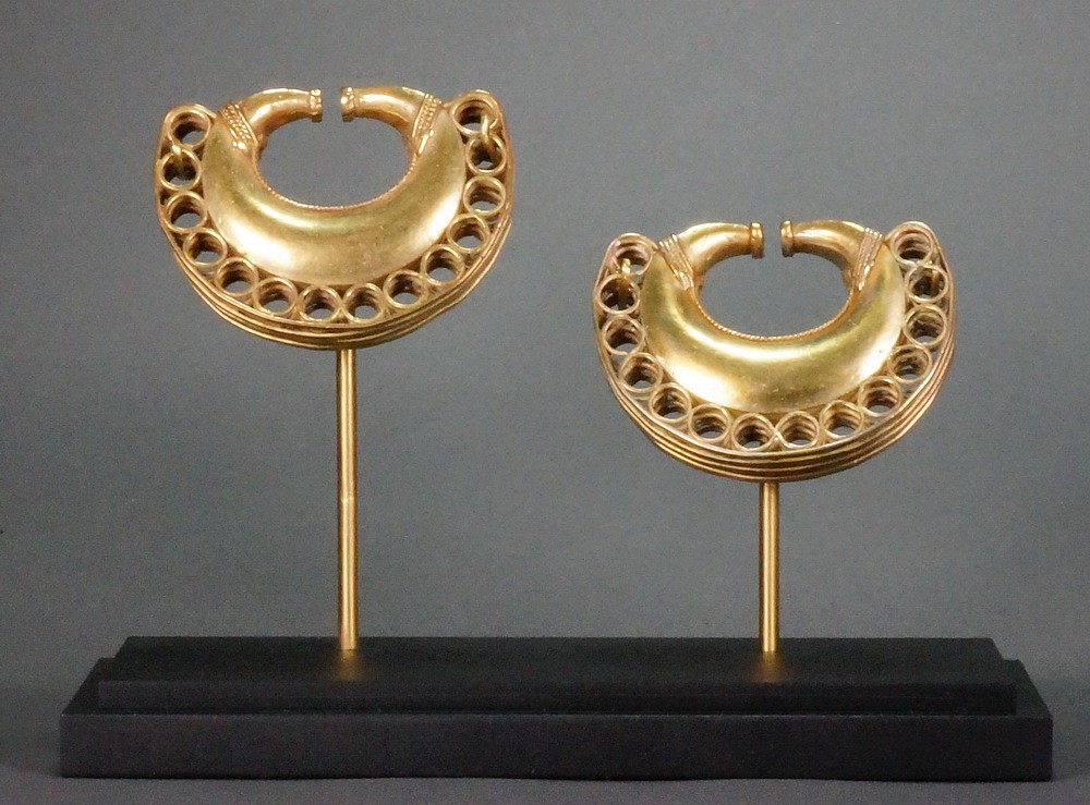 Colombia, Tairona Pair of gold lost wax cast ear ornaments decorated with braidwork
This is a particularly strong and heavy pair of matched ear ornaments from the Tairona people who were known for their fine casting work.  A very similar pair is illustrated in THE GOLD OF ELDORADO  by Warick Bray pg. 164.
Media: Metal
Dimensions: Width: 2 3/4" x Height: 2"   Weight: 48.4 & 49.6 grams XRF: Au. 49.1%, Ag. 7.6%, Cu. 42%
&bull;SOLD
n8012