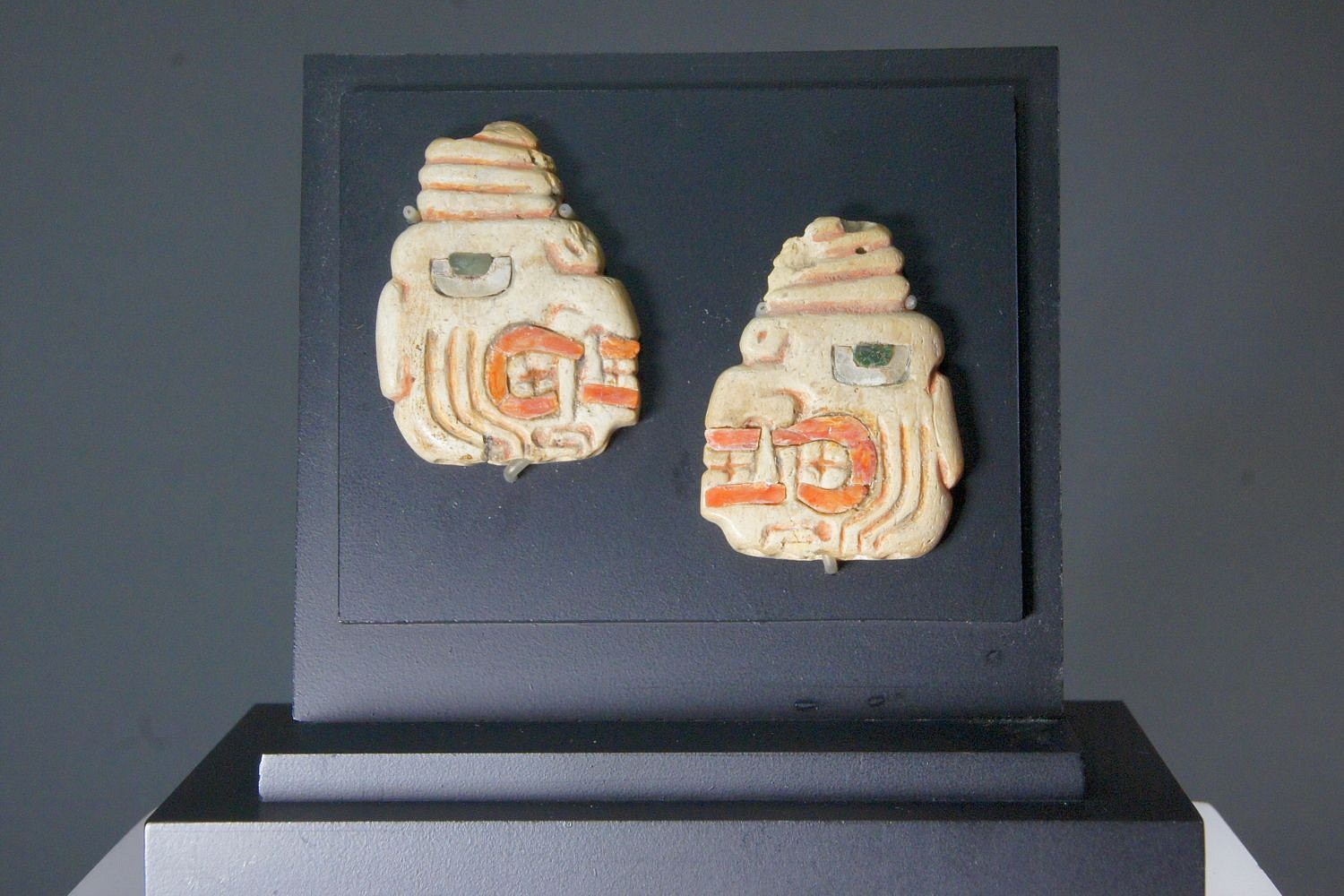 Peru, Pair of Chavi­n Shell Ear Pendants with Fanged Deity Heads Wearing Turbans
This pair of ear pendants inlaid eyes with shell and turquoise pupils. The teeth are also inlaid with shell.  Both profiles wear knotted turbans. The faces are similar to the large stone tenoned heads found at Chavín de Huantar.  A similar pair can be found in the "Handbook of South American Indians," Volume II, Julian H. Steward, ed. (1963: pl. 62).
Media: Shell
Dimensions: Height 1 3/4" x Width 1 1/2"
$7,500
97137