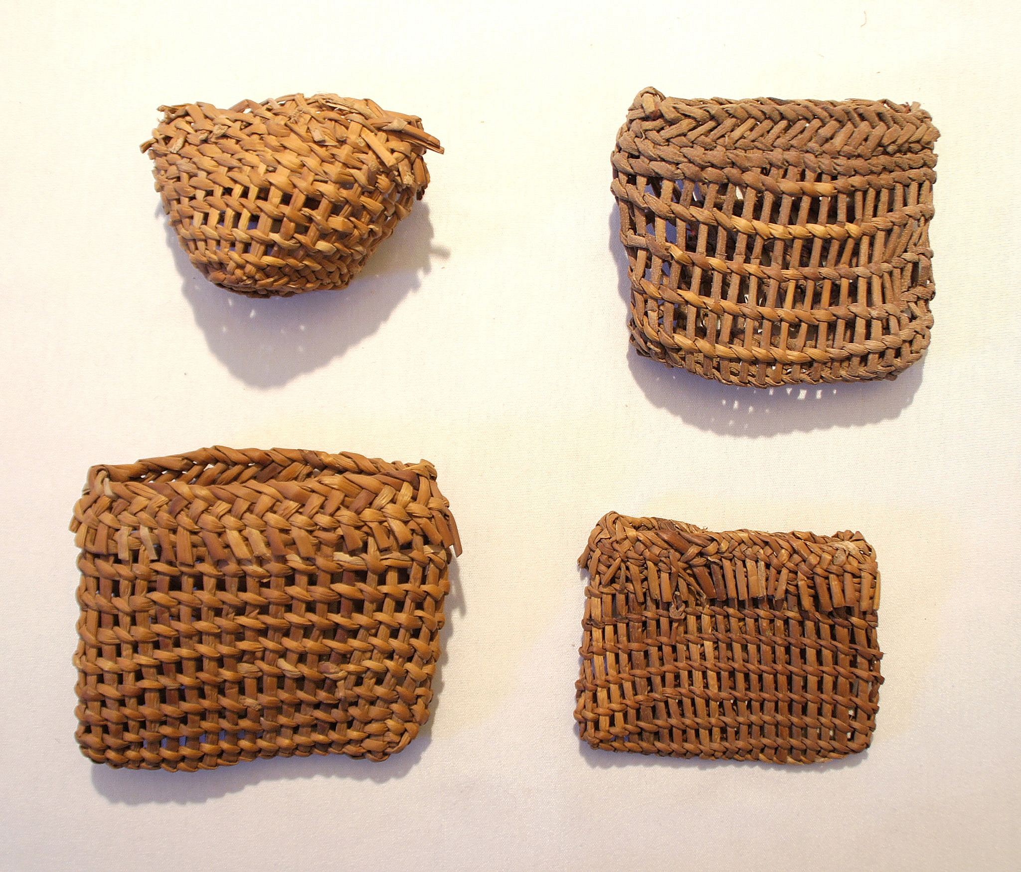 Chile, Eight Twined Baskets For Fishing Line and Hooks
These small baskets made of tule reed were decorated with different patterns.  The baskets were just big enough to hold a hook, line and sinker.  It is possible that all four baskets were made by the same maker.
Period: Chile, Arica, formative period, c. 1000 BC - AD 300
Media: Wood
Dimensions: Height: 1.25" - 1.75"
N6025