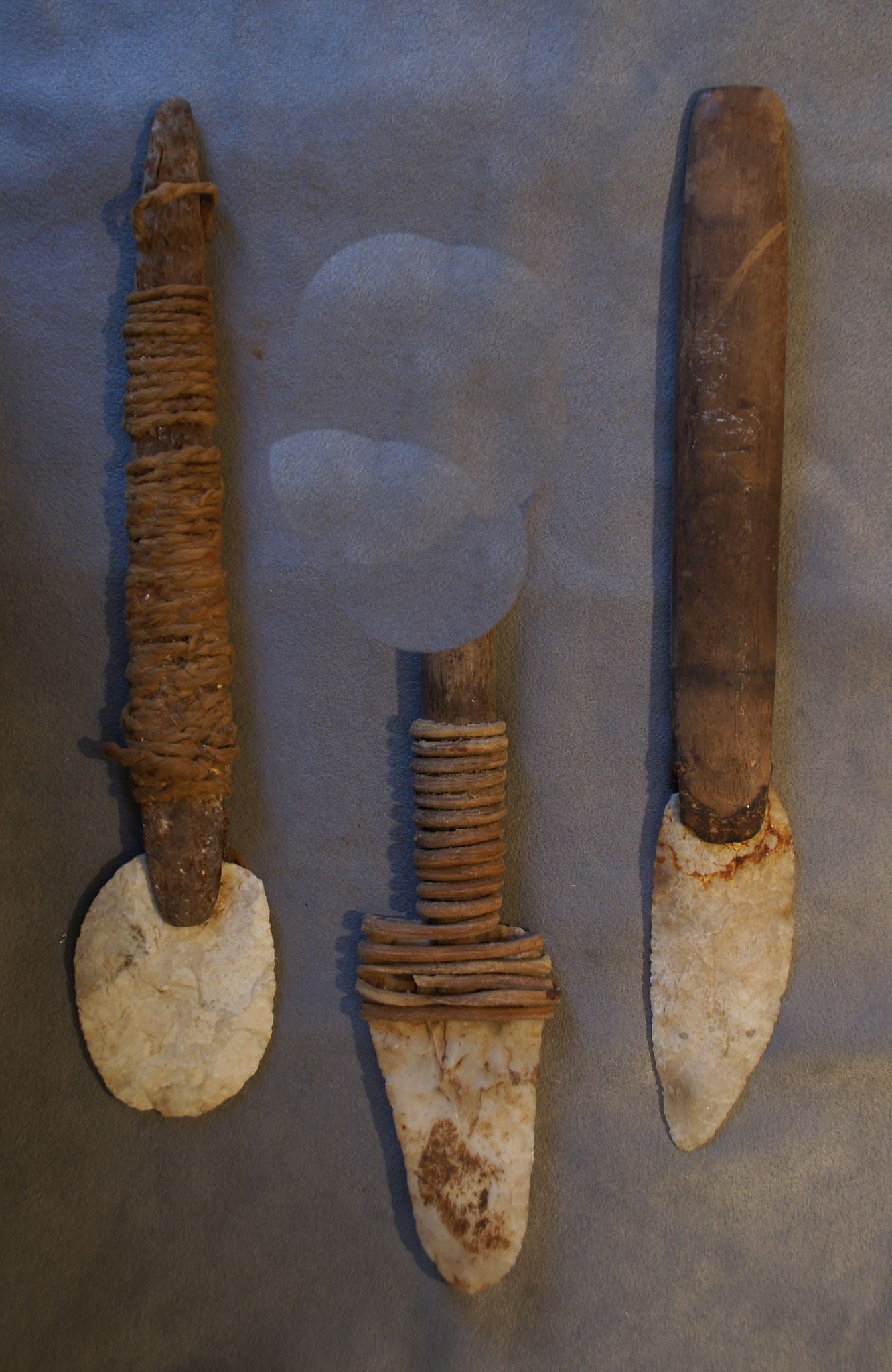 Chile, Three Claming Tools With Napped Broad Points
These tools were used to find and pry open clams and mussels on the sandy shoreline.  Hemp or leather secured the points to slits in the wooden shafts.  Traces of glue indicates that they used tree resin to secure the points in the shafts.
Media: Wood
Dimensions: Length: 9" each.
n6030
