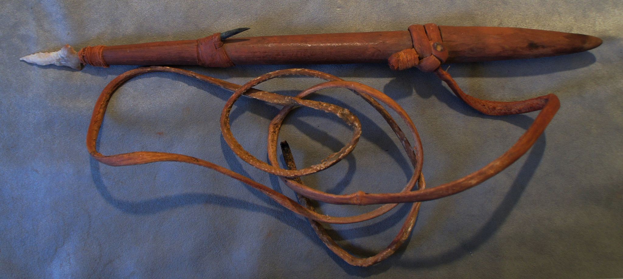 Chile, Large Whaling Harpoon Forepiece with Stone Point, Copper Barb, and Original Leather Line
The harpoon shaft is  maded of carved hardwood with a hole for the knapped stone point, and tapered socketed end.  The leather line is wrapped and knotted around a grooved band to prevent the line from sliding off.  The barb is copper and lashed into a groove.
Media: Wood
Dimensions: Harpoon: 18.5"; Line: approx 4.5"
n6040