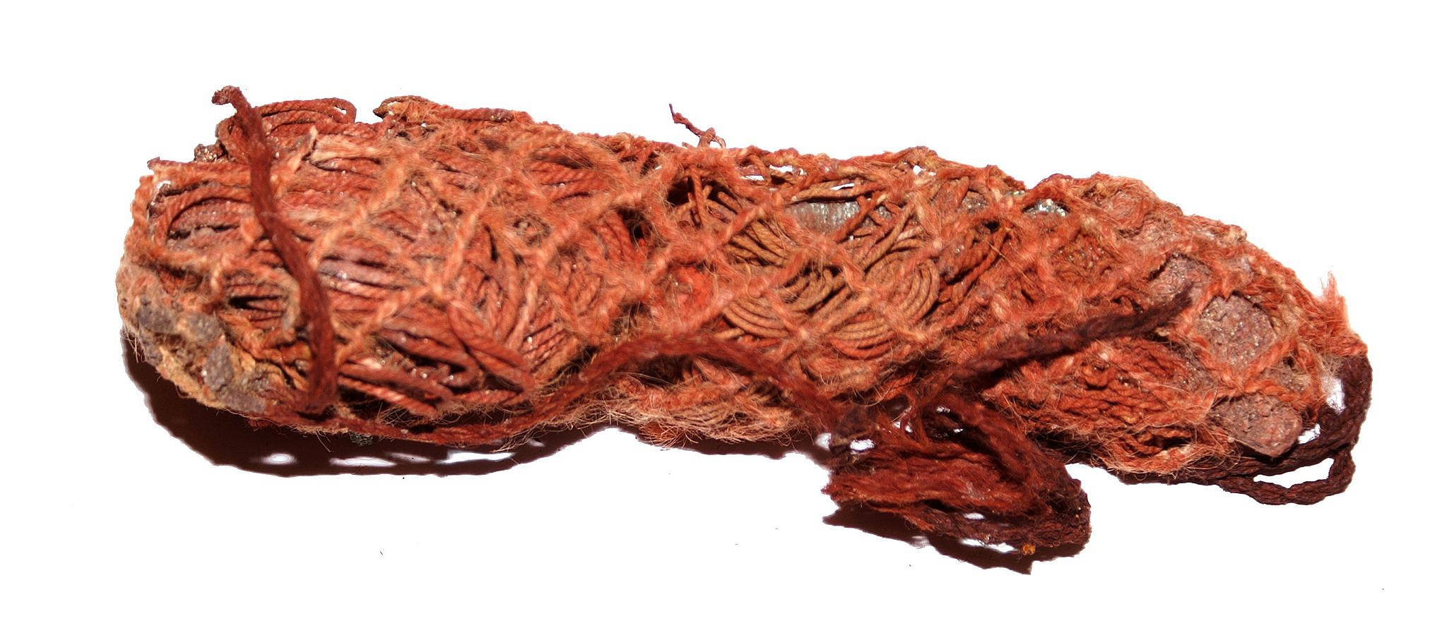 Chile, Fishermans' Kit for the Afterlife
This fisherman's kit has two lines of twined cotton, a stone sinker, and copper hooks, all of which have fused together with age.   The kit has been dyed red, indicating that it was for the afterlife.
Period: Chile, Arica, Far North Coast, c. AD 900 - 1200
Media: Textile
Dimensions: Length: 6"
n6043