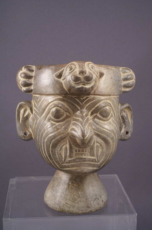 Peru, Moche Grayware Rattle Cup with the Decapitator
A well modeled portrait of Ai Apaec wearing his characteristic puma ring headdress with its tail incised on the back of the vessel. The perforated base of the cup contains clay beads which make the vessel rattle with movement. Ai Apaec was an old wrinkled god associated with war and sacrifice, hence his other titles as the Decapitator and Wrinkle Face.
Media: Ceramic
Dimensions: Height: 5 1/4" x  Width: 4 1/2"
$5,200
M3147