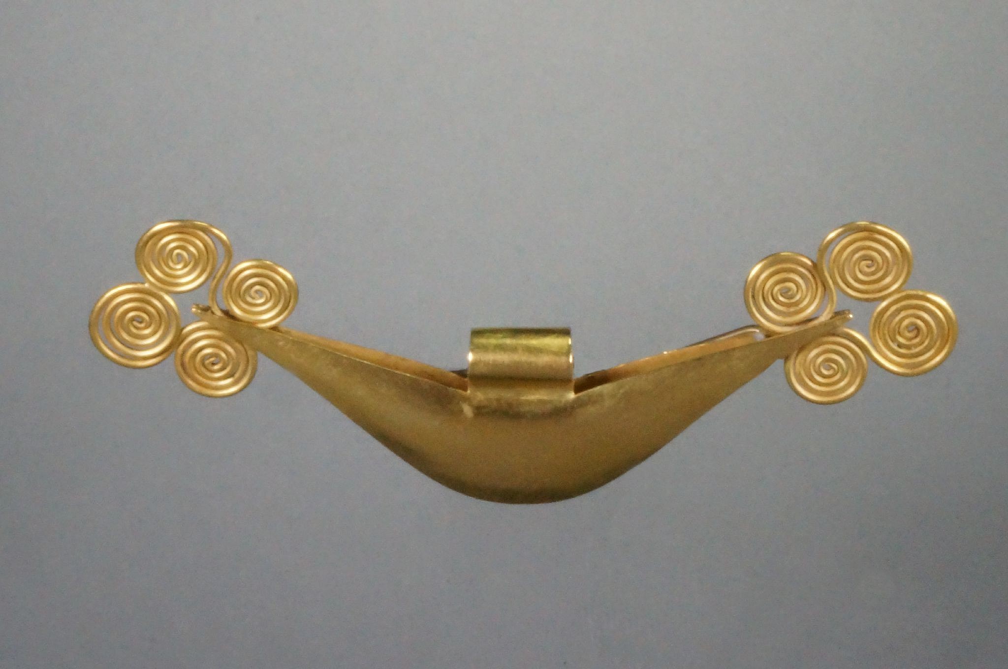 Peru, Vicús Gold Crescent Tweezers with Four Spirals on Each End
An elegant gold nose ornament with four wire spirals expertly soldered on each end.  Made of two oblong sheets of gold with soldered filigree spirals reveals a high degree of craftsmanship.  Tweezers were status implements fabricated in copper, silver and gold, with gold reserved for the highest level of status.   Tweezers are often confused with nose ornaments, however they are spring loaded by annealing the metal, and were used to pluck the thick facial hairs of the Andean people.  Shaving was not done in the New World, but was widely practiced in Europe and the Middle East.
Period: Peru, Vicus, Far North Coast, c. 300 BC - AD 300
Media: Metal
Dimensions: Width 6"  Weight: 36.5 gramsXRF: Au. 83.8%, Ag. 20.0%, Cu.5.1%
Price Upon Request
96050