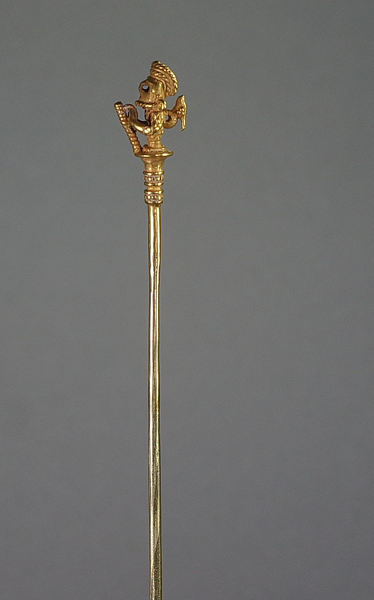 Colombia, Calima Cast Gold Lime Dipper of a Warrior with Animal Perched on Back
Finely cast with tapering shaft terminating in two bands of granulation. Elaborate helmeted warrior wearing a mask and holding a staff with both hands, curving headdress and miniature animal perched on back.  According to the research, only limited types of images were used for lime dippers, usually shamans or warriors.  See "Calima and Malagana," by Marianne Cardale Schrimpff, p. 115, plate 111.34 for a similar example.  Excellent example of lost wax casting.  Sothebyâ€™s, New York, private collector, prior to 2000.
Period: Colombia, International style, AD 700 - 1000
Media: Metal
Dimensions: Height: 8 1/4"
$14,750
MM618