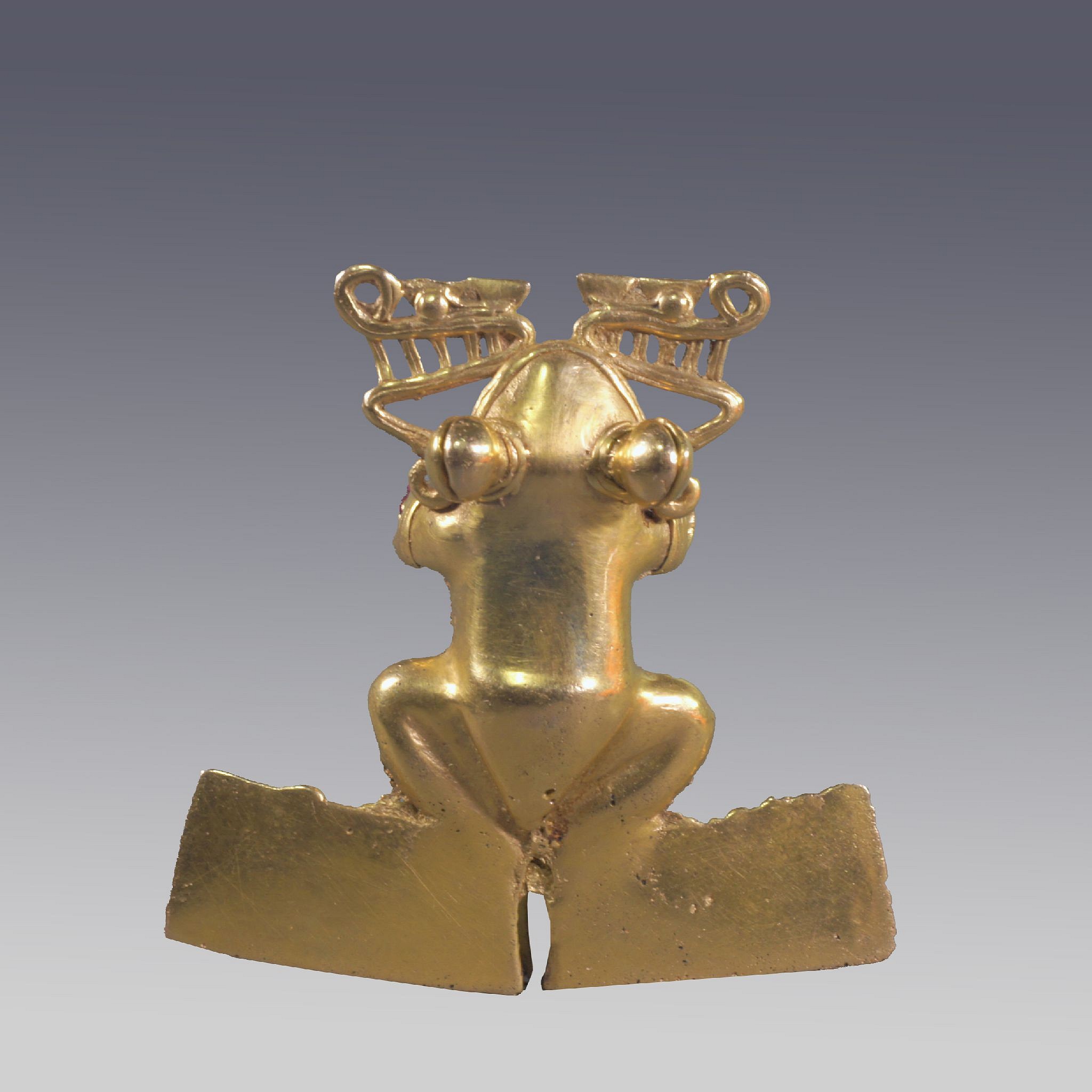 Panama, Diquis Gold Frog With Large Hind Flippers and Bulbous Eyes
The Frog has a classic body with his front legs becoming the suspension loops. From the mouth emanate two saurian heads back to back, with a mythological significance.  The eyes each have a solid pellet inside to make noise when the frog is being worn.  A similar example is illustrated in the Catalog, BETWEEN CONTINENTS/BETWEEN SEAS: Precolumbian Art of Costa Rica, fig. 287.  A similar frog is also the Rockefeller Collection at the Metropolitan Museum of Art.  Originally photographed by Justin Kerr #3081, 2001.
Media: Metal
Dimensions: Length: 3 3/4" x Width:3 1/2"    Weight: 65 gramsXRF Au.68.5% Ag.03%, Cu. 31%
&bull;SOLD
n4028