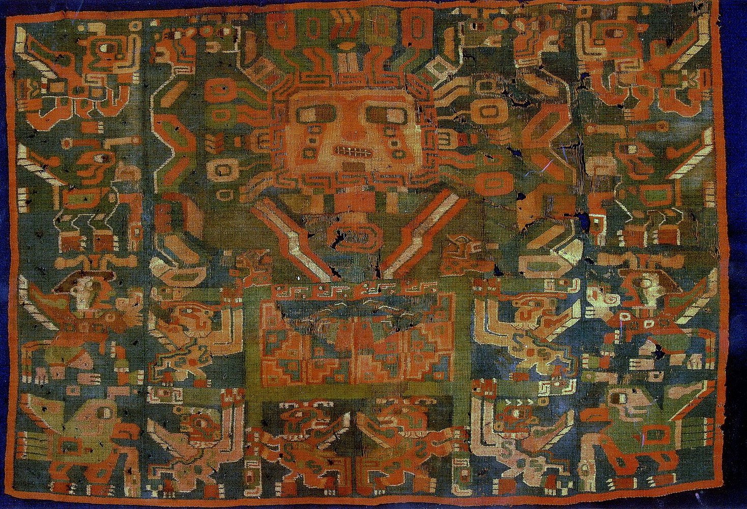 Peru, Sihuas Tapestry Panel Depicting a Sun Face Deity Holding a Staff in Each Hand
The panel depicts an elaborate Sun Face Deity holding fancy staffs with Puma heads in profile.  The Deity wears a colorful headdress and an unusual chest decoration.  Beneath the deity is a litter held by four attendants.  In the center of the litter is a self-referential depiction of a tunic.  Underneath the litter are two staff bearers that appear in front of the litter.  On each side is a column of four unique kneeling anthropomorphized attendants with bird-like characteristics. Among the attendants are two figures with human faces who are blowing conch trumpets. A similar, less complicated example is illustrated in TIWANAKU: ANCESTORS OF THE INKA by Maragaret Young-Sanchez, fig. 1.9.
Condition: There are losses and repairs throughout.
Media: Textile
Dimensions: Height: 20" x Width: 29"
$18,000
N6012