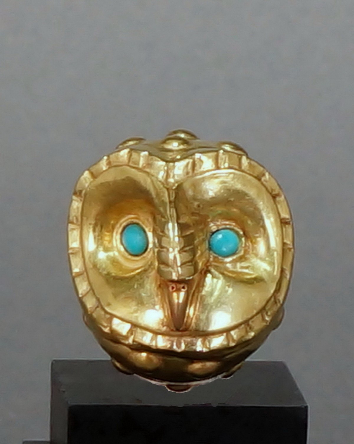 Peru, Moche Small Gold Male Condor Bead with Turquoise Eyes
This gold bead is identifiable as a male eagle by the caruncle on the beak.  The beak itself is crated in a slightly reddish colored gold.  It is made in two parts, expertly soldered.  There are four suspension holes that allow for the bead to be hung upright.  Ex Collection Benno Mattel, prior to 1970, by decent to his daughter Karin Ashburn.
Media: Metal
Dimensions: Height: 3.3cm x Depth: 3.2cm x Weight:10.2 grams
$5,000
n8021