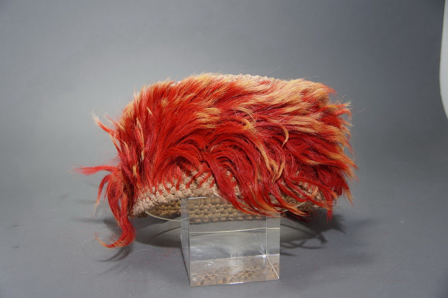 Peru, Nasca Headband with Orange Tie-dye Llama Hair
These unusual headbands are made of a cotton knotted mesh with shanks of llama hair tied into the knots.  The inside does not show any of the shanks of hair.
Media: Textile
Dimensions: Diameter 7.5" x Height 4"
$2,750
p1040