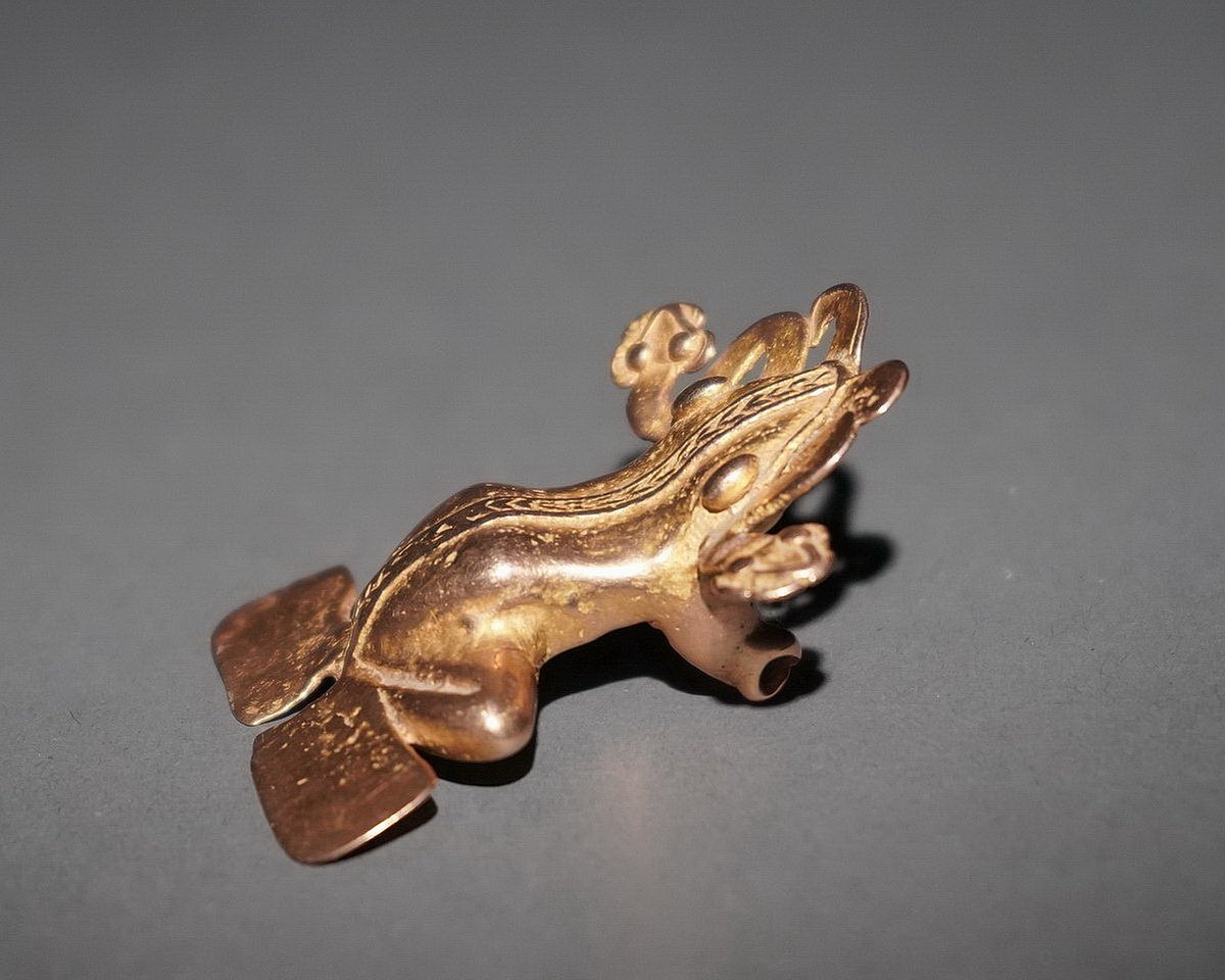 Panama, Classic Veraguuas Cast Gold Frog with Serpents
This beautiful cast gold frog has  large spherical eyes and a ribbon down its back and bordering its flippers.  There is a modern suspension loop hung from the original suspension arrangement.  Jan Mitchell collection, prior to 1970, by descent to his sons.
Period: Panama, Veraguas, c. AD 1000
Media: Metal
Dimensions: Length: 2 7/8" x Width: 1 3/4"  Weight: 32.4 grams.
$6,500
p1045a