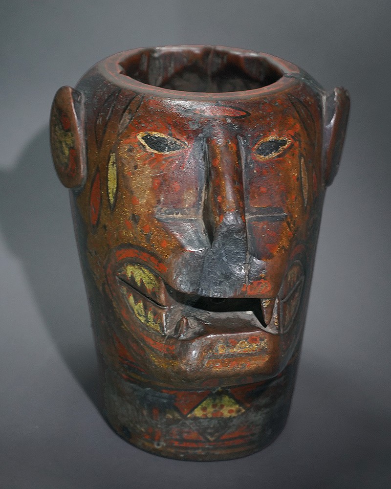 Peru, Colonial Kero in the Form of a Feline Head
Originally the Inca used these carved vessels for ceremonial and festive occasions.  This tradition lasted through the late 18th Century.   Shaped keros were introduced in the Colonial period and their design is limited to 3 specific types of animal motifs: alpaca, llama, feline.  They were also made to resemble Inca lords.   Keros were made in pairs; and the pair to this Kero is at the Yale Peabody Museum and is illustrated in â€œMachu Picchu: Unveiling the Mystery of the Incasâ€ on p.212.  The vessel may represent an ocelot rather than a jaguar or puma because of the pelage markings, which indicate that it represents a tropical forest feline.  The back of the kero is carved and painted with a scene depicting a battle scene between Inca troops and tropical forest warriors known as the Chunchus - the last group that the Inca conquered.  The waxy colored inlay pigments, known as mopa-mopa, came from Pasto, Colombia and the carved wood is mainly from the Escallonia genus of shrubs and trees.  A similar kero is illustrated in â€œMACHU PICCHU: Unveiling the Mystery of the Incas,â€ on pg. 212.  This kero was formerly in the collection of Nelson Rockefeller and was sold at Sotheby's on November 5, 1980, in lot 75.
Media: Wood
Dimensions: Height: 8 3/4"  Widest point on top: 6".
Price Upon Request
n8014