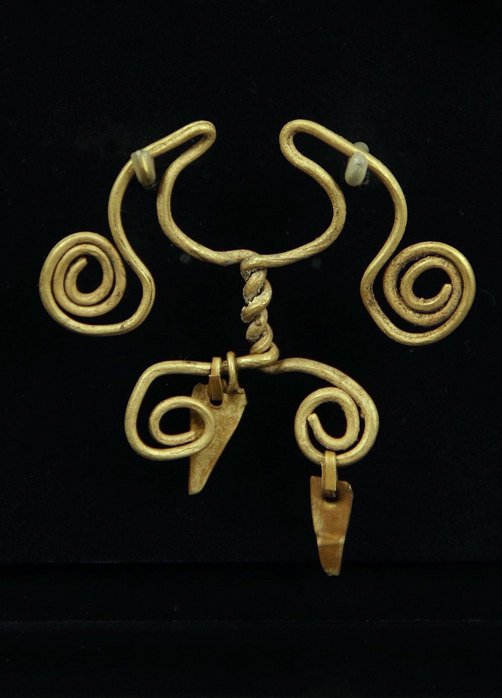 Peru, Chavin Gold Spiral Nose Ring with Two Twisted Wires and Two Dangles
This wire nose ring was made of one hammered sheet of gold, folded on itself, and cut.   The ornament was hammered and coiled with the original suspended dangles.

Media: Metal
Dimensions: Height:1 1/4"   Weight: 4.8 grams
$2,100
94222