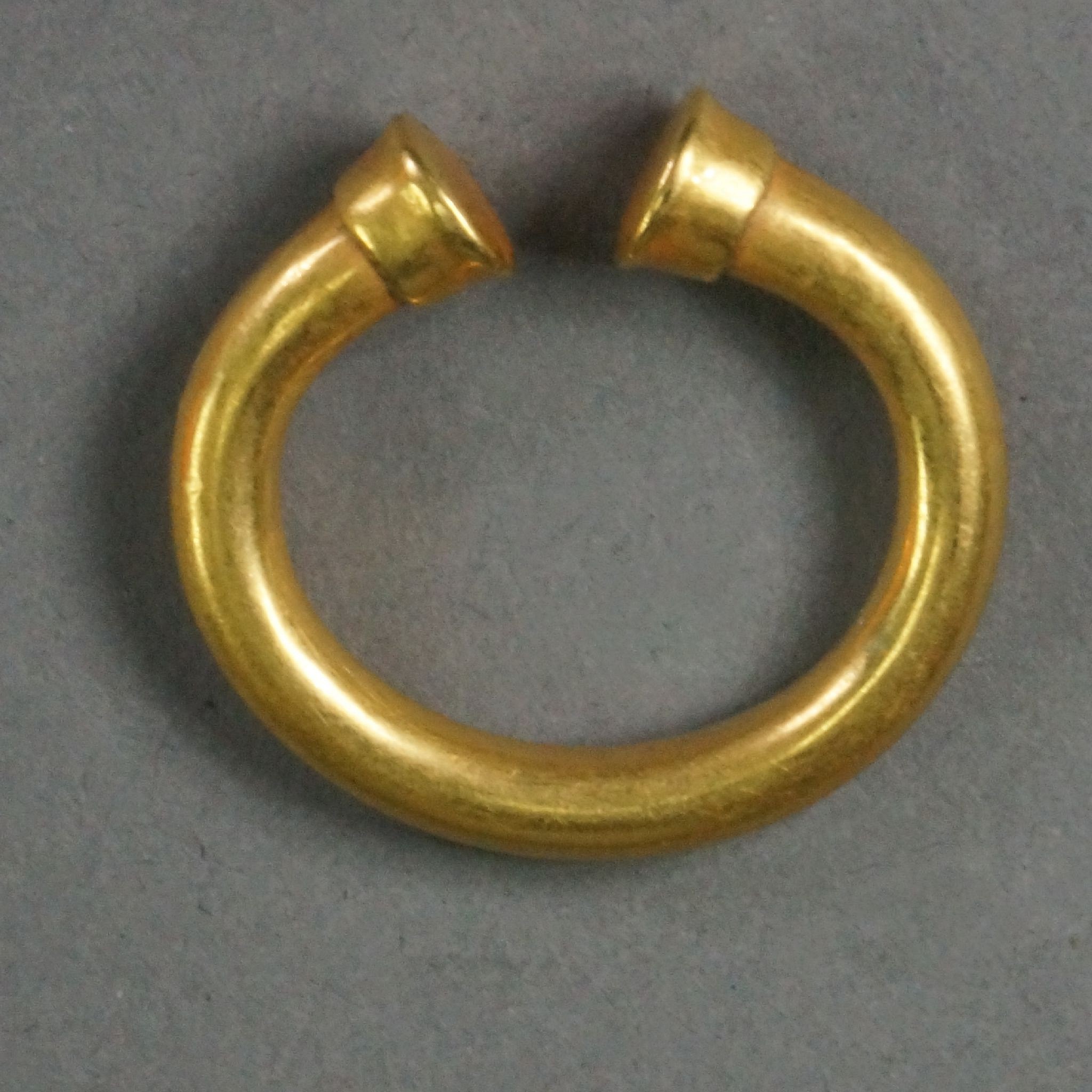 Colombia, Sinu Ring with Capped Ends
This high-karat, solid gold ring is has a lovely burnished finish.  The cylindrical caps are typical of the Sinu, and are individually hammered onto the ends.
Media: Metal
Dimensions: Diameter: 1" 3/16"   Weight: 16.4 grams
$2,500
n7034