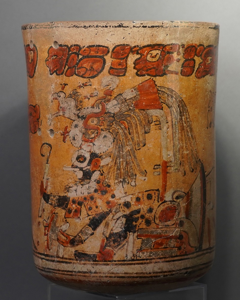 Guatemala, Mayan Polychrome Ceramic Cylinder Vessel with Ruler and Otherworld Serpent Deity
This compelling Mayan painted cylinder depicts a ruler, or cacique, enthroned in the jaws of the Serpent Deity from the otherworld. The top register of the vessel contains the Primary Standard Sequence - a sequence of characters identified by scholar Michael Coe in The Maya Scribe and His World in 1973.  These glyphs are repeated in a similar formation on many vessels and are thought to be associated with Mayan myth and ritual.  The Mayans believed that human souls were required as a sacrifice to propel the eternal wheel of cosmic order, and that the sacrificed souls would live beyond the death of the body.  Fierce anthropomorphized serpent figures, such as the one depicted here, were employed by the Mayans to represent the archetypal forces of death and sacrifice.
Scholar Justin Kerr (mayavase.com) lists this cylinder as being affiliated with the term Och Chan Yopat, which means "the storm god enters the sky."  This phrase is also found on a Mayan frieze that in Guatamala, described by Rachel Newer in The Smithsonian Magazine on August 9, 2013.  This phrase describes the terrible, formidable nature of the cacique as well as the serpent god.  The vase is painted in broad, sweeping lines of motion, using vibrant red blocks and aggressive black lines that weave in and out and morph from curving to linear. Acquired in Tokyo, Japan, prior to 1970.
Kerr database #K937 (mayavase.com).
Period: Guatamala, Mayan, c. AD 400 - 800
Media: Ceramic
Dimensions: Height: 7 7/8" x Diameter: 5 3/4"
Price Upon Request
N5022
