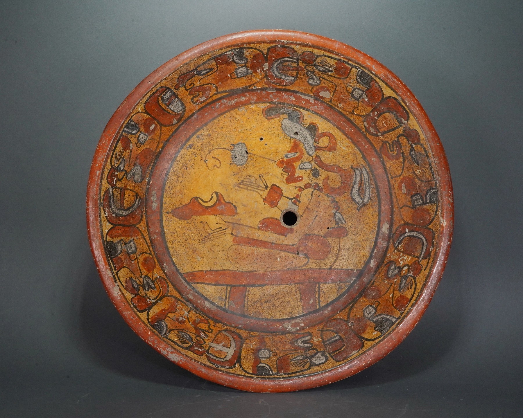 Guatemala, Mayan Tripod Dish with Seated Figure
This painted Mayan tripod dish features eight repeating  glyphs of deity heads in profile painted around the inside  edge.  The central seated figure is likelay shaman.  He is  holding two birds, which represent communication.   There is a "kill hole" in the center of the dish.  The back of the dish is painted with scallop design.  Formelry in the collection of Hiroshi Muira, Tokyo, Japan, prior to 1980.
Media: Ceramic
Dimensions: Diameter: 11" X Height: 3 1/2"
Price Upon Request
n6012B