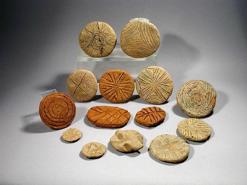 Dominican Republic, Taíno  Group of 14 Round Ceramic Seals or Stamps
This eclectic group of ceramic seals of is decorated with various geometric designs, one with zoomorphic motif (frog or bat) on the grip.  The Taíno  dipped these stamps in pigments made from crushed bija and jagua seeds and then imprinted them on their own skins for ceremonial events. Similar examples are illustrated in "Altos de Chavon", p. 28.
Period: Dominican Republic, Taíno , c. AD 1000 - 1500
Media: Ceramic
Dimensions: Largest  diameter: 3"  smallest diameter: 1 1/4"
99155