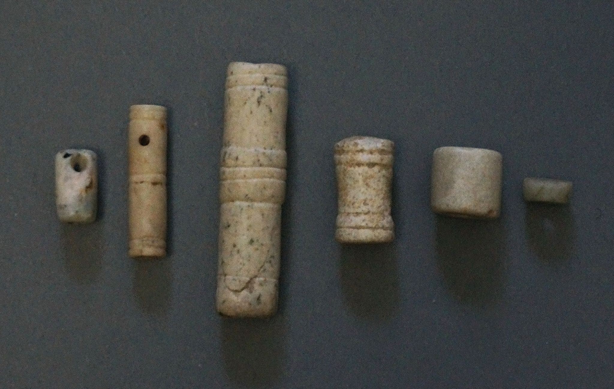 Dominican Republic, Set of Six Taíno  Cylindrical Stone Beads
These beads are examples of the delicate craftsmanship that the Taíno  employed even for the simplest of ornaments.  Cylindrical beads were carefully shaped and drilled.  It took great effort to drill longitudinally, especially if the bead was slender or long. The beads range in shape from cylindrical, to tapered, to plain discs (discoidal).
Period: Dominican Republic, c. AD 1000 - 1500
Media: Stone
Dimensions: Height: 1/4" to 2"
99377