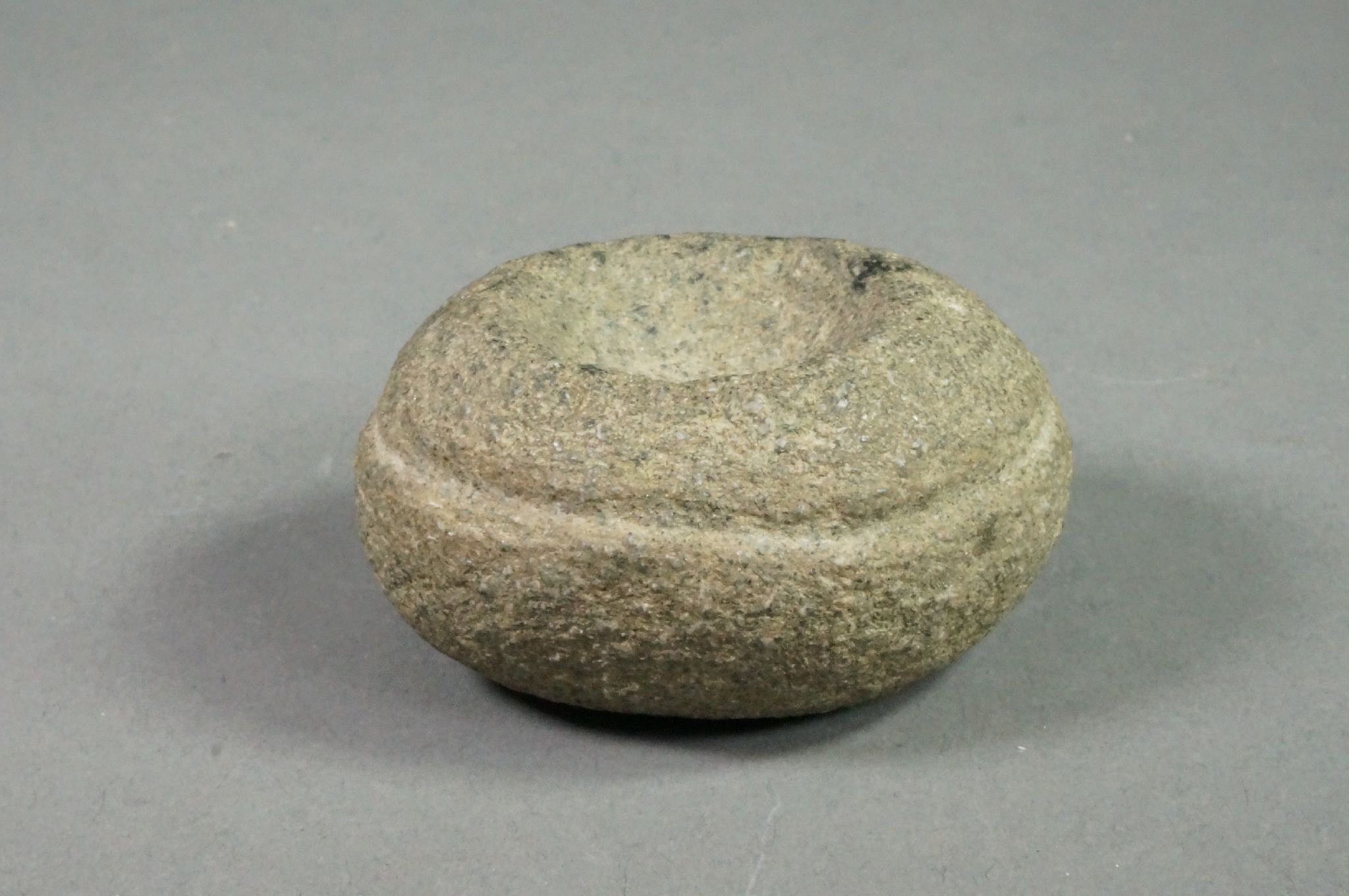 Dominican Republic, Pre-Taíno Miniature Circular Stone Mortar
This small mortar was probably used to crush small amounts of potent drugs. The incised circle around the outside may have been used to run a string to rotate the mortar with a push and pull.
Period: Dominican Republic, Courian Subseries, c. 2000 BC - AD 250
Media: Stone
Dimensions: Diameter: 1 7/8"
98164