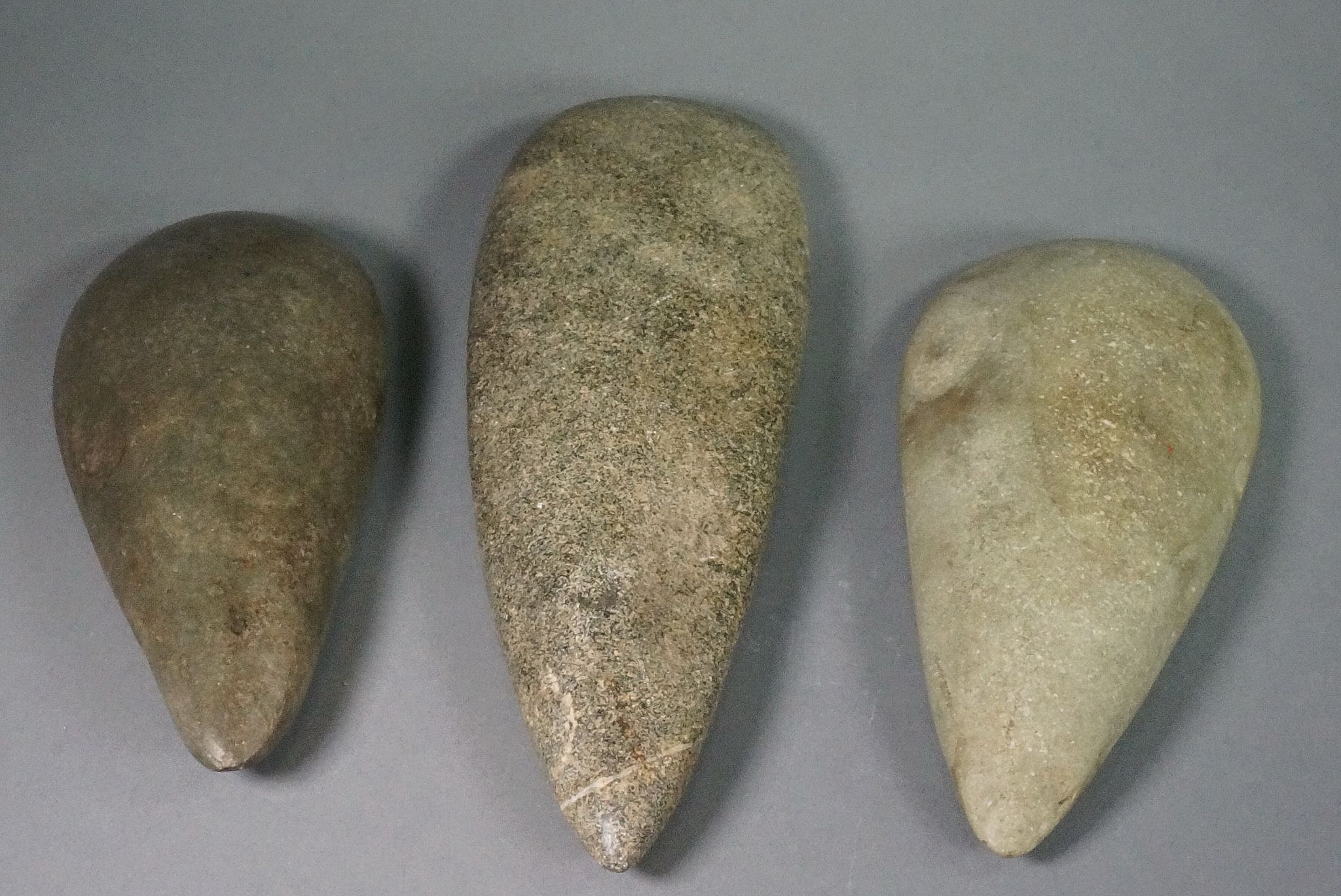 Dominican Republic, Three Pre-Taíno Stone Adzs of Different Colors
Each adz would have been lashed perpendicularly to a wooden shaft so that it would strike its target to make a wide cut.  Adzs are rare in comparison to petaloid celts.  The tips were lashed to the shaft, and the adzs shows signs of use.
Period: Dominican Republic, Casimiroid, c. 4000 BC - AD 400
Media: Stone
Dimensions: Top: Length 9" Center: Length 7 1/4" Bottom: Length 6 3/4"
n7009